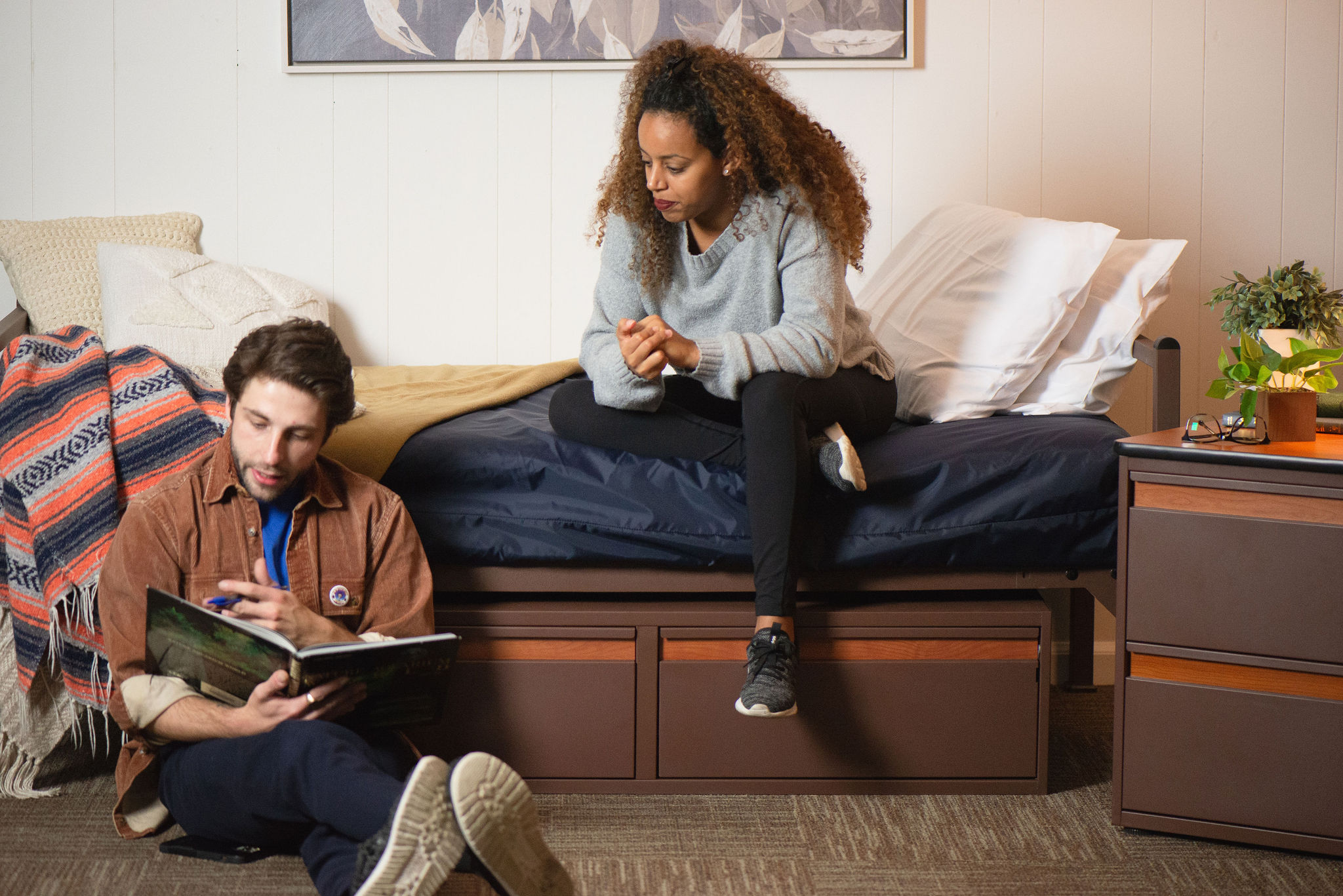 Students in dorm studying on bed